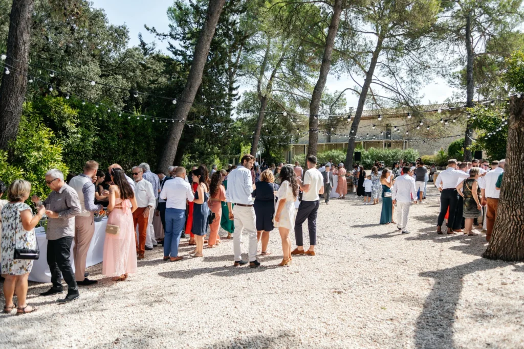 Cocktail de mariage en extérieur sous les pins au Domaine de Christin dans l'Hérault avec guirlandes lumineuses