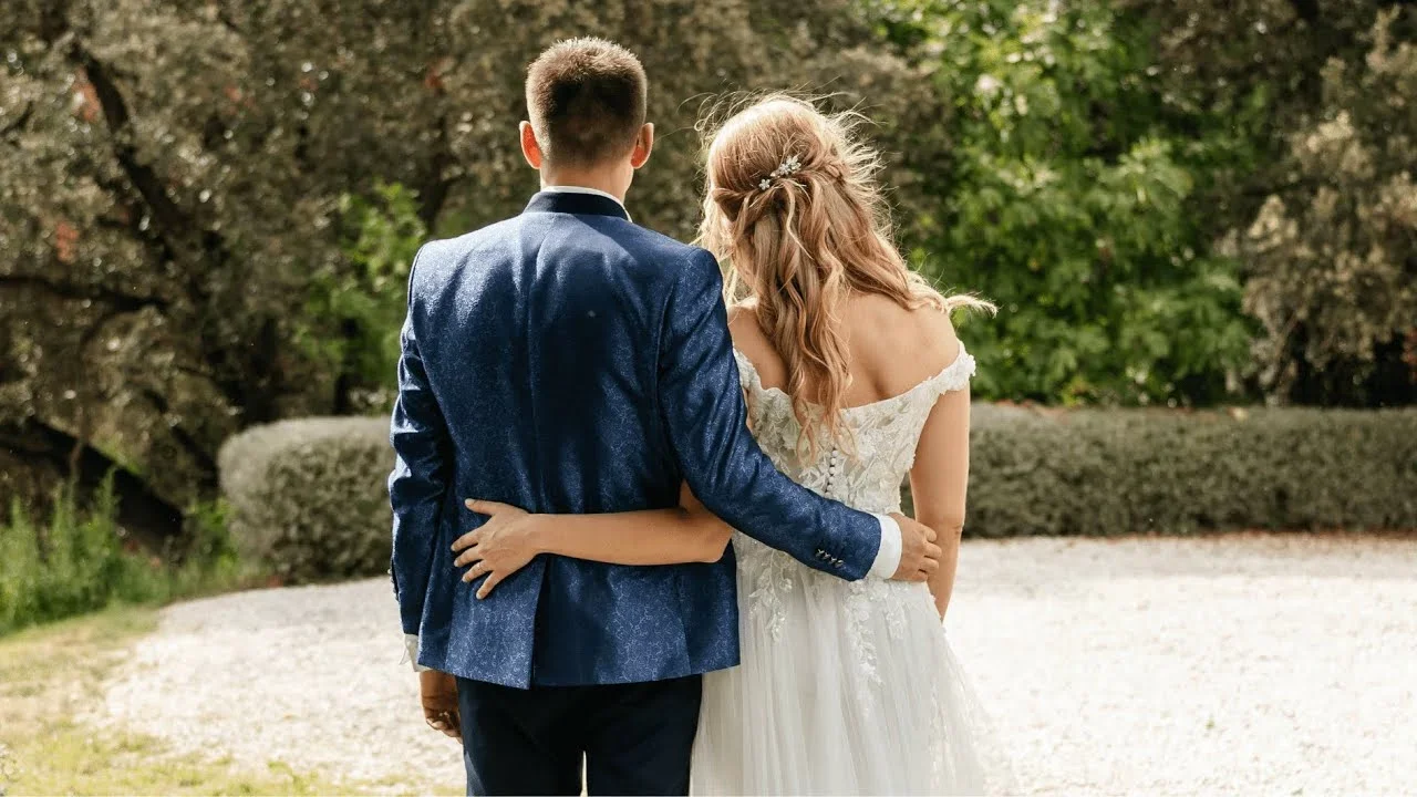 Couple de mariés se promenant enlacés dans le parc arboré du Domaine de Christin dans l'Hérault