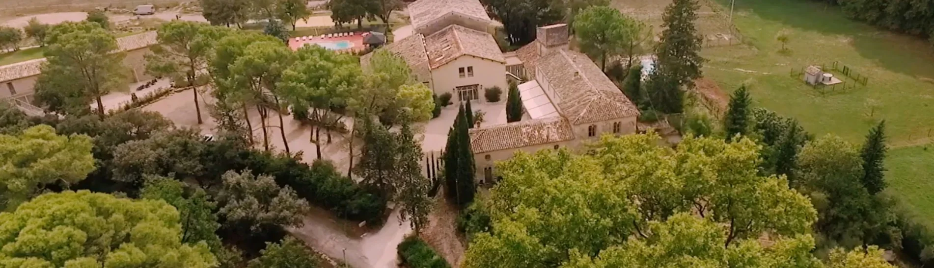 Vue aérienne du Domaine de Christin dans l'Hérault, domaine de mariage entouré d'arbres méditerranéens et de vignobles