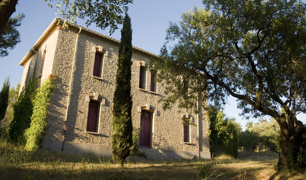 Bâtiment annexe en pierre avec cyprès et oliviers au Domaine de la Clapière, hébergement mariage Hérault