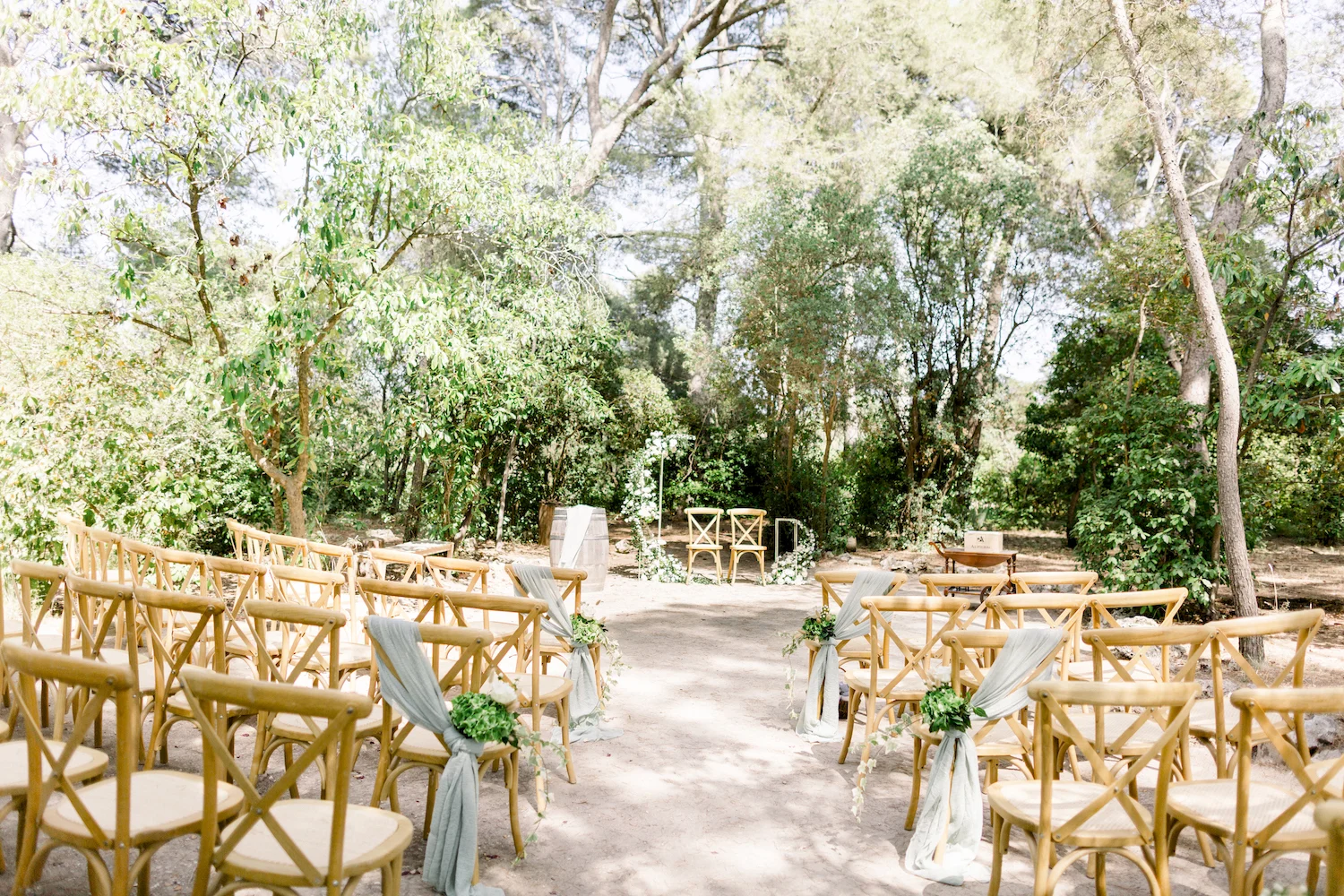 Cérémonie laïque en forêt au Domaine de la Grange Hérault - allée avec chaises bois et arche végétale naturelle