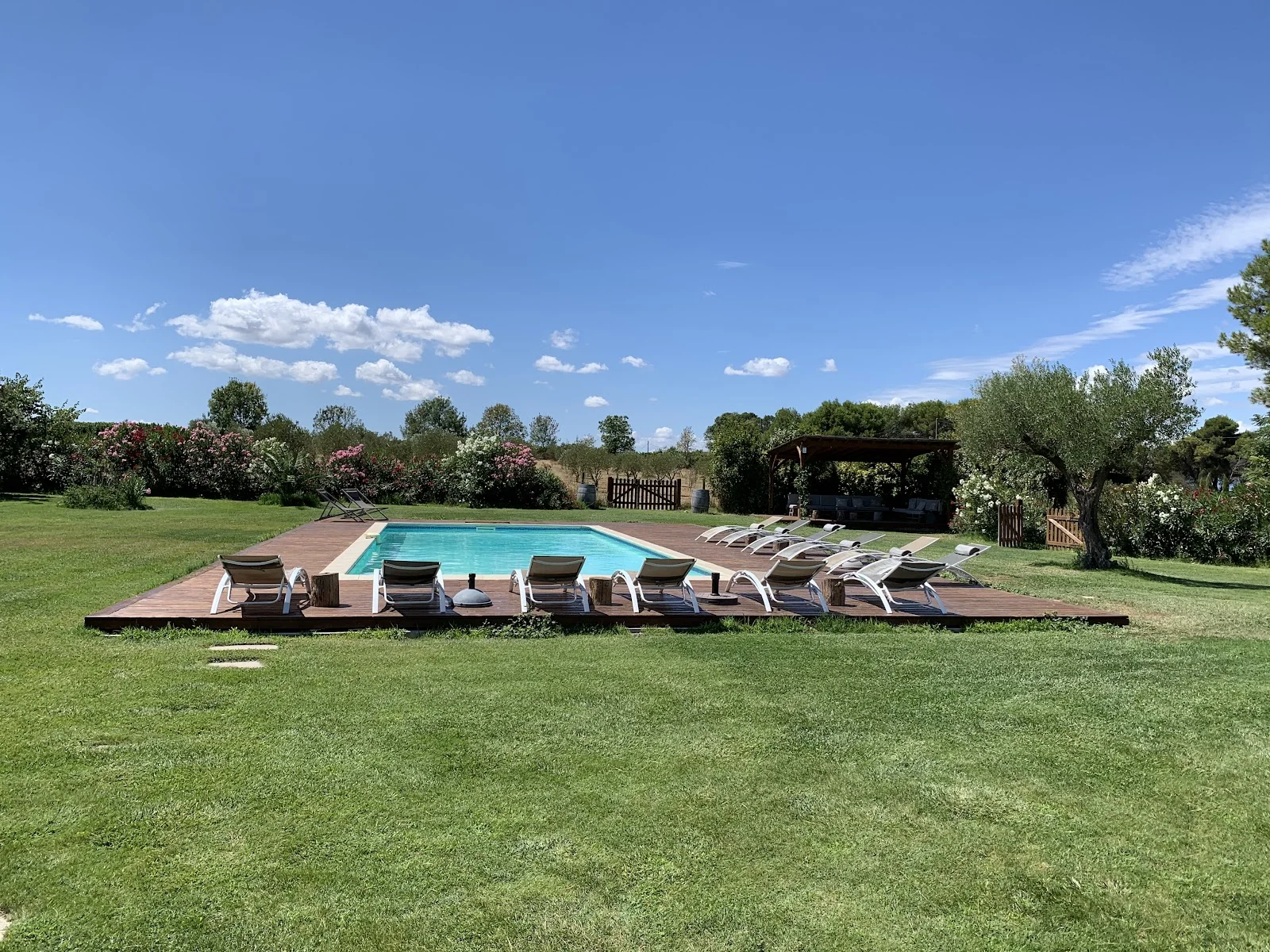 Piscine et pelouse verte du Domaine de la Grange Hérault - espace détente pour mariage en Languedoc sous ciel bleu
