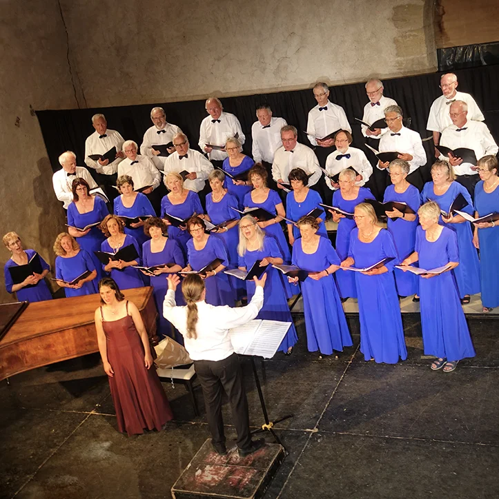 Concert de chœur au Domaine de la Tour dans l'Hérault, femmes en robes bleues et chef d'orchestre dirigeant le spectacle