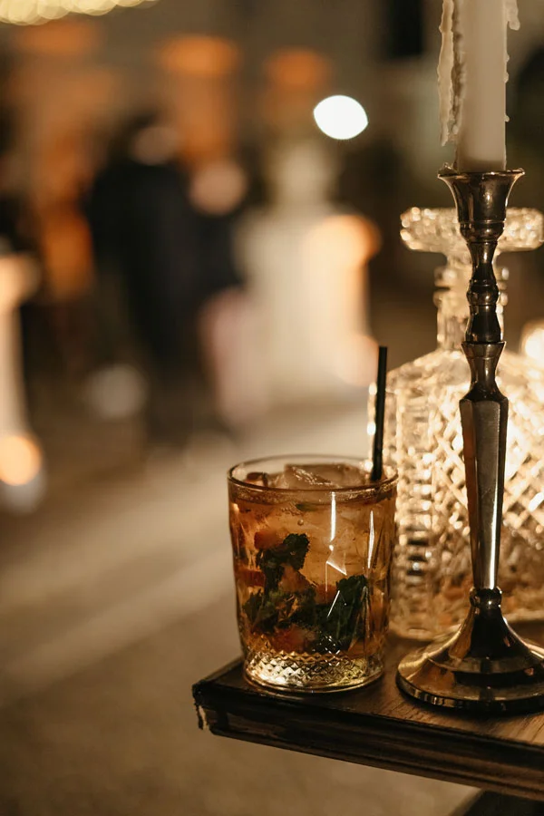Cocktail servi lors d'une soirée mariage au Domaine de La Tour Montpellier, verre cristal et bougie ambiance dorée