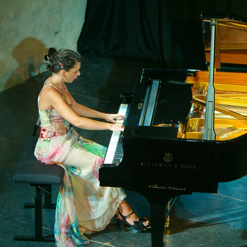 Pianiste en robe florale jouant sur un Steinway & Sons au Domaine de la Tour, récital mariage Hérault