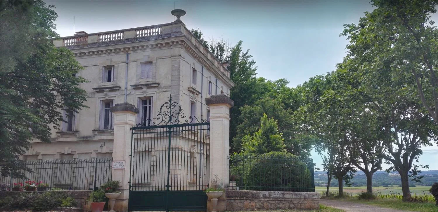 Vue extérieure du Domaine de la Tour avec grille en fer forgé et façade néoclassique, lieu de mariage en Hérault