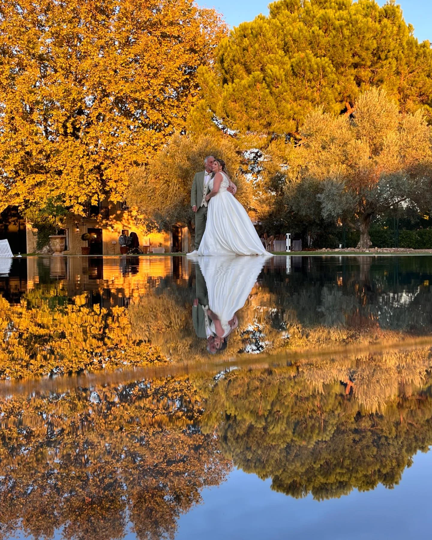 Couple de mariés se reflétant dans le miroir d'eau du Domaine de la Trinité en automne, Hérault