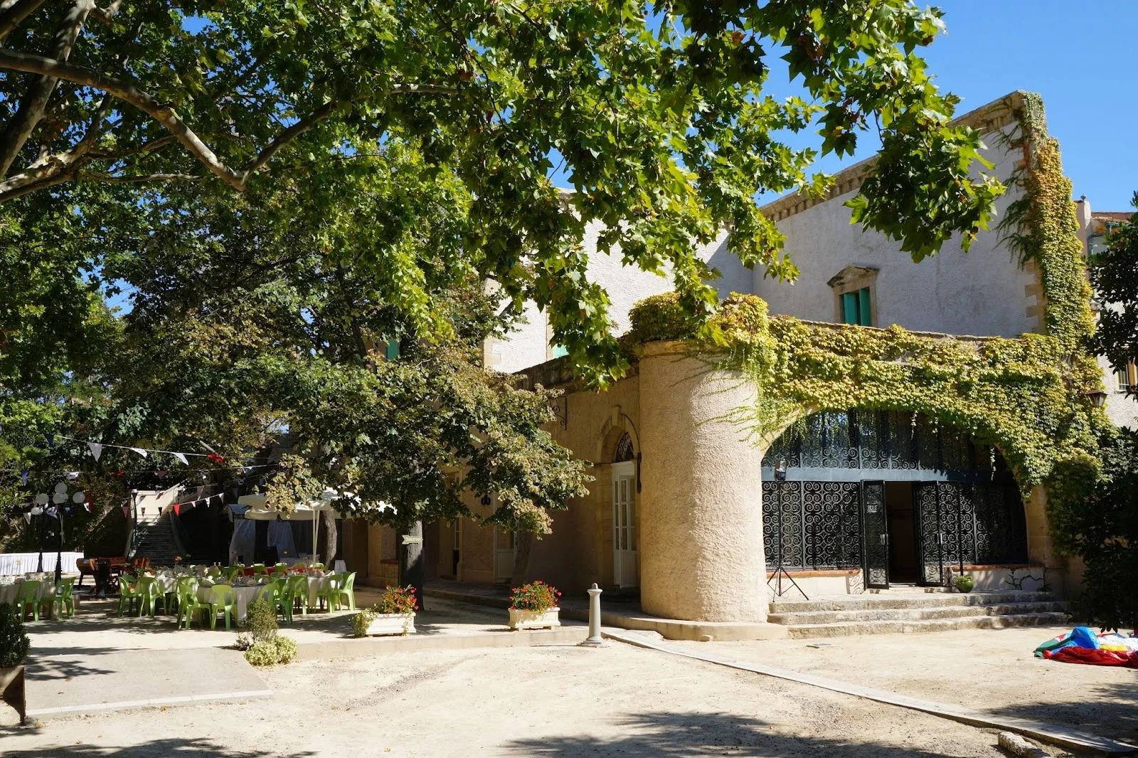 Façade principale du Domaine de l'Argentière avec arche en pierre et cour intérieure ombragée, lieu de mariage Hérault