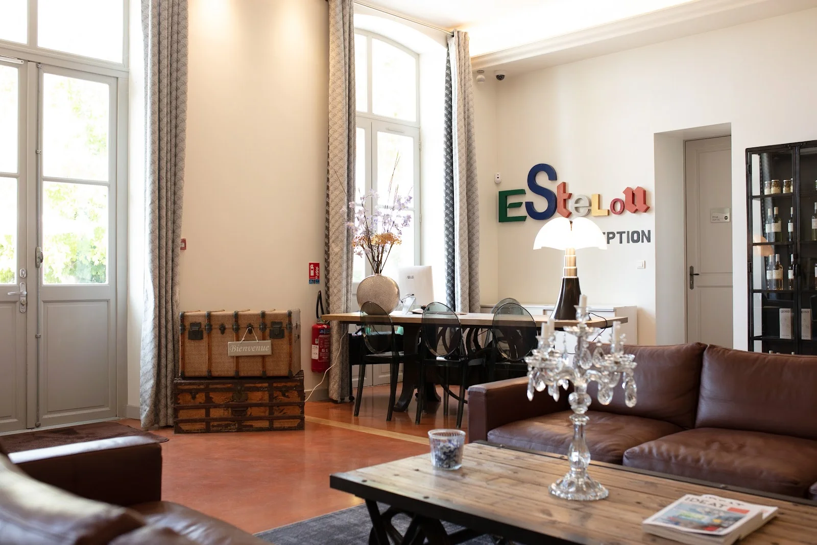 Hall de réception avec canapés cuir et enseigne colorée au Domaine de l'Estelou - lieu de mariage Hérault