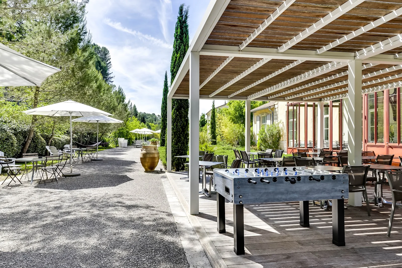 Terrasse couverte avec pergola blanche et baby-foot au Domaine de l'Estelou - lieu de mariage dans l'Hérault