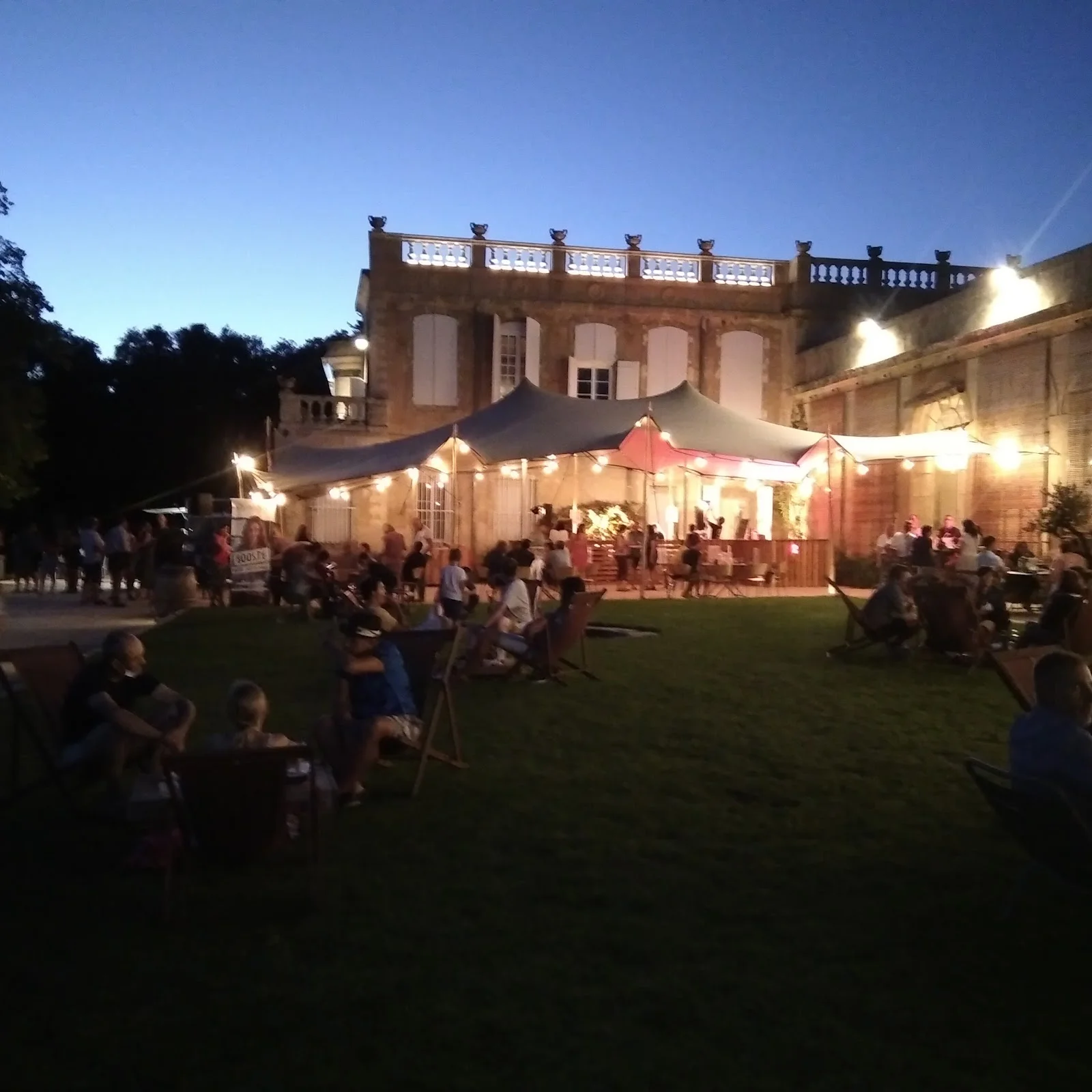 Vue nocturne du Domaine de Rieucoulon avec château illuminé, tentes et pelouse lors d'un mariage dans l'Hérault