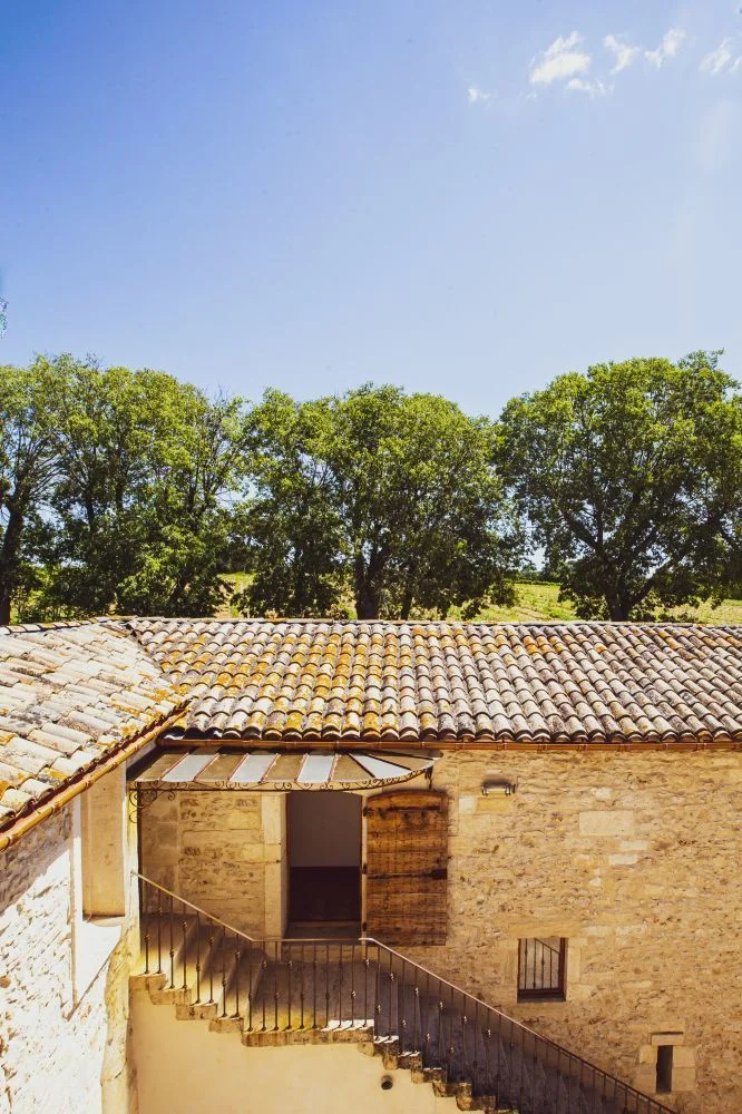 Bâtiment annexe en pierre du Domaine de Verchant avec balcon et vue sur les vignes en Hérault