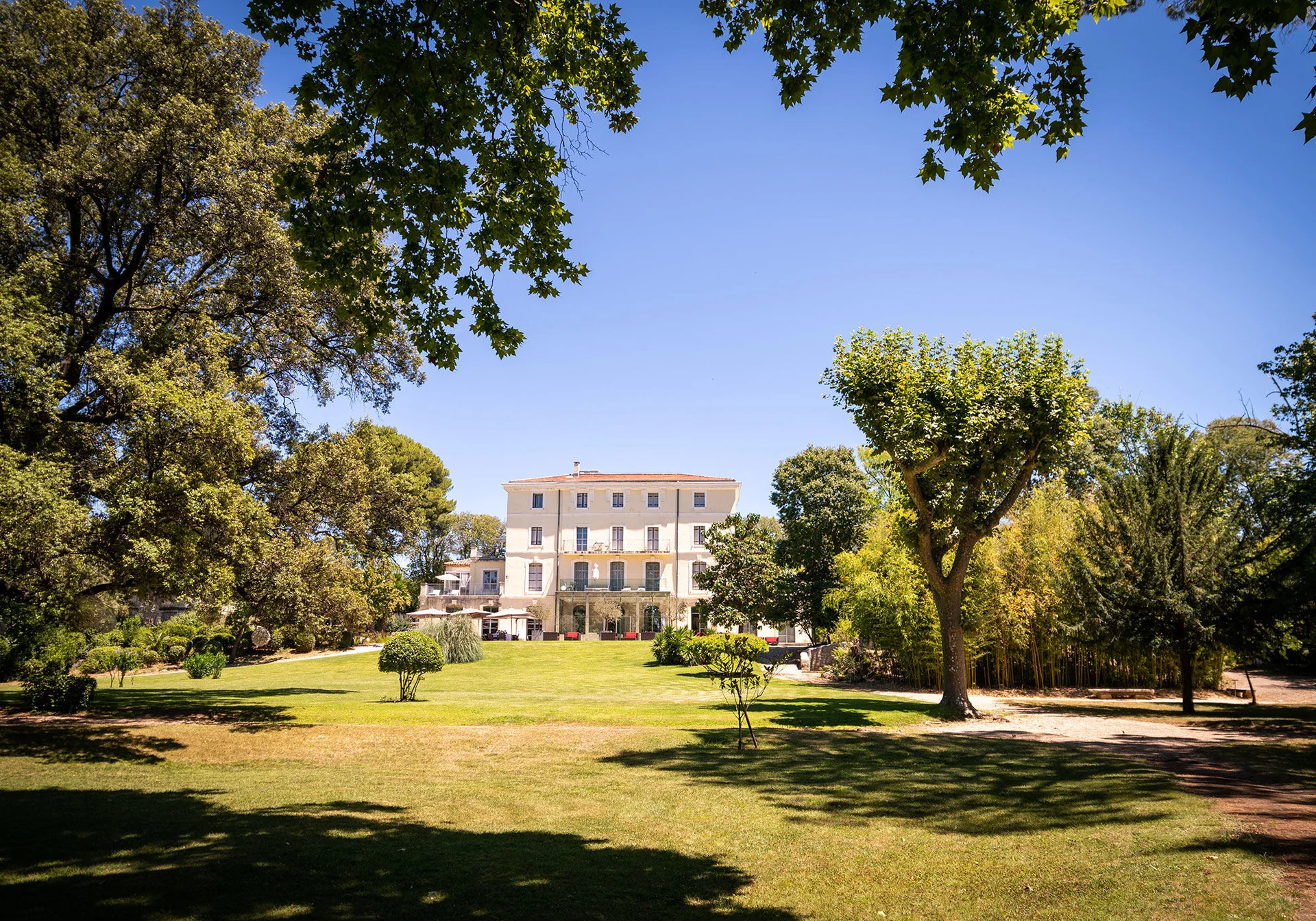 Vue du château Domaine de Verchant depuis le parc arboré avec grande pelouse, mariage Hérault