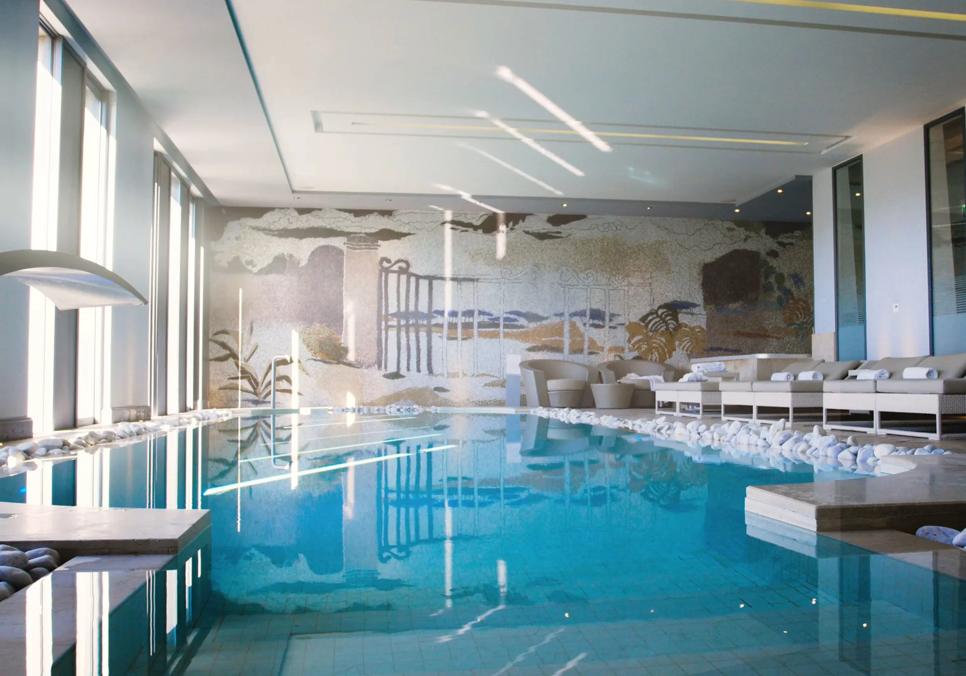 Piscine spa intérieure du Domaine de Verchant avec mosaïque murale antique et lumière naturelle, Hérault