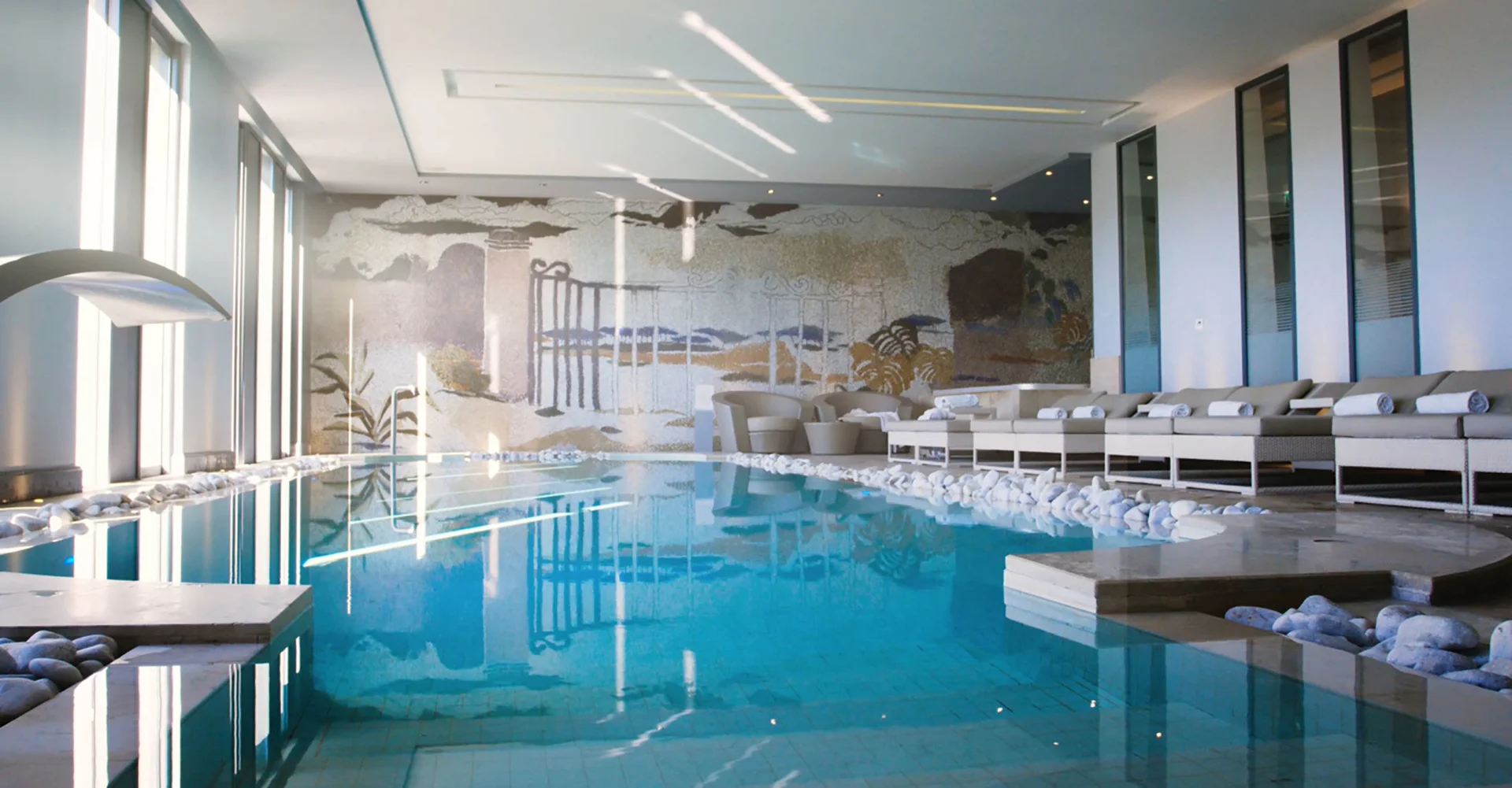 Piscine intérieure spa du Domaine de Verchant avec mosaïque murale et transats, Hérault