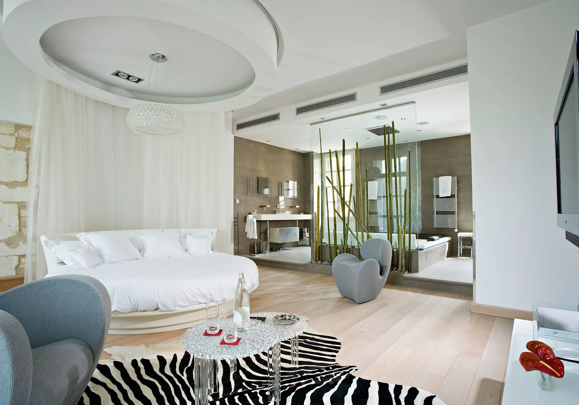 Suite de luxe avec lit rond et salle de bain ouverte au Domaine de Verchant, hébergement mariage Hérault