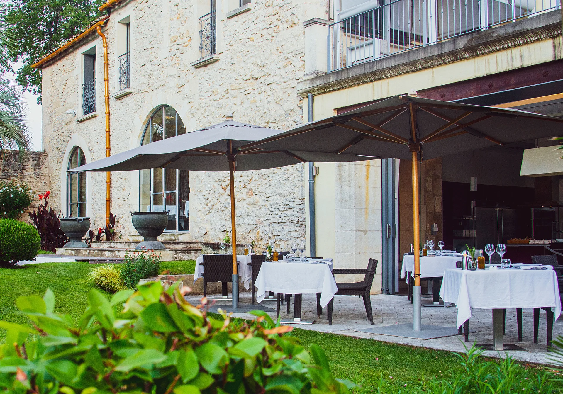 Terrasse gastronomique du Domaine de Verchant avec tables dressées sous parasols, réception mariage Hérault