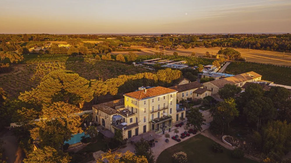 Vue aérienne complète du Domaine de Verchant avec château, vignes et jardins en Hérault au coucher du soleil