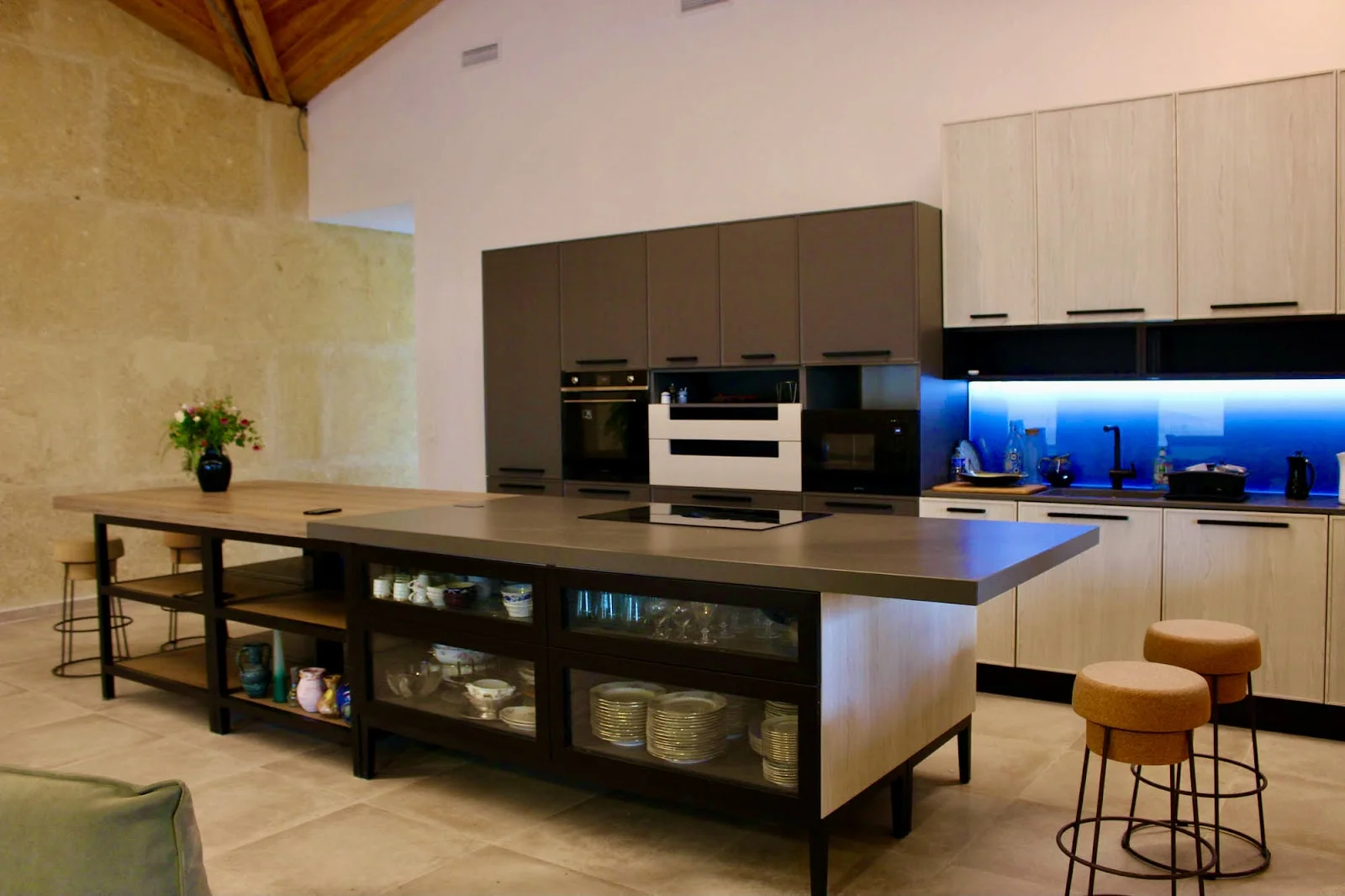 Cuisine professionnelle moderne du Domaine des Hospitaliers Hérault avec îlot central et murs en pierre