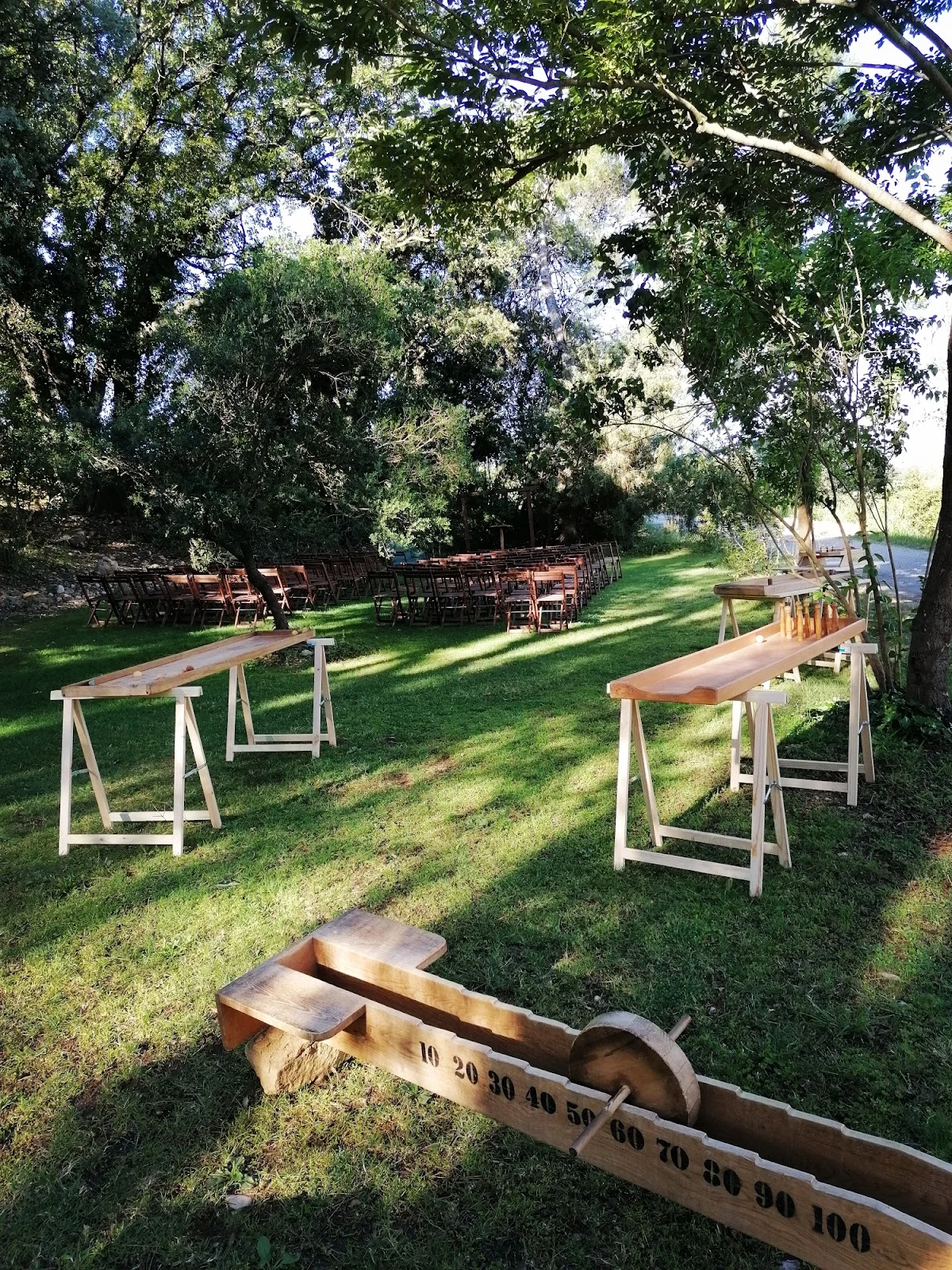 Espace cocktail et jeux de jardin mariage Domaine des Hospitaliers Hérault avec tables bois et pétanque