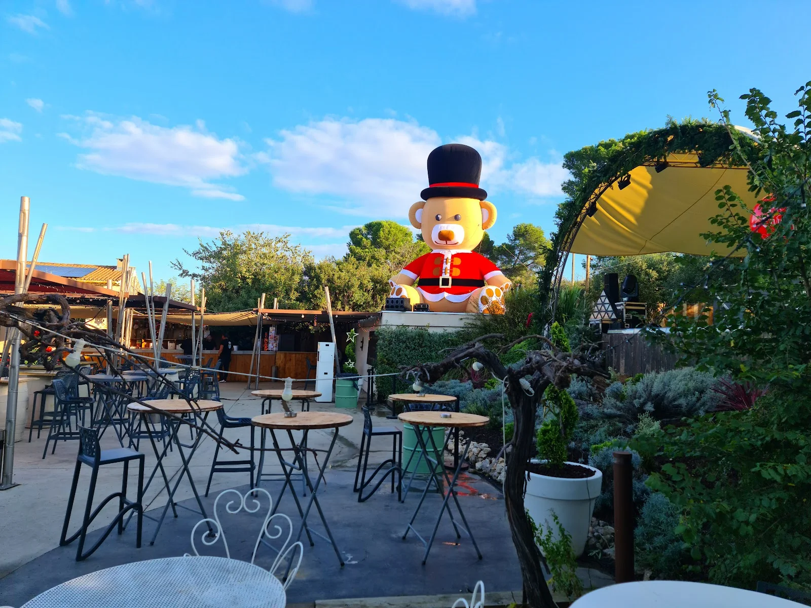 Espace cocktail du Domaine des Laux Hérault décoré pour Noël avec ours géant gonflable et tables hautes en terrasse