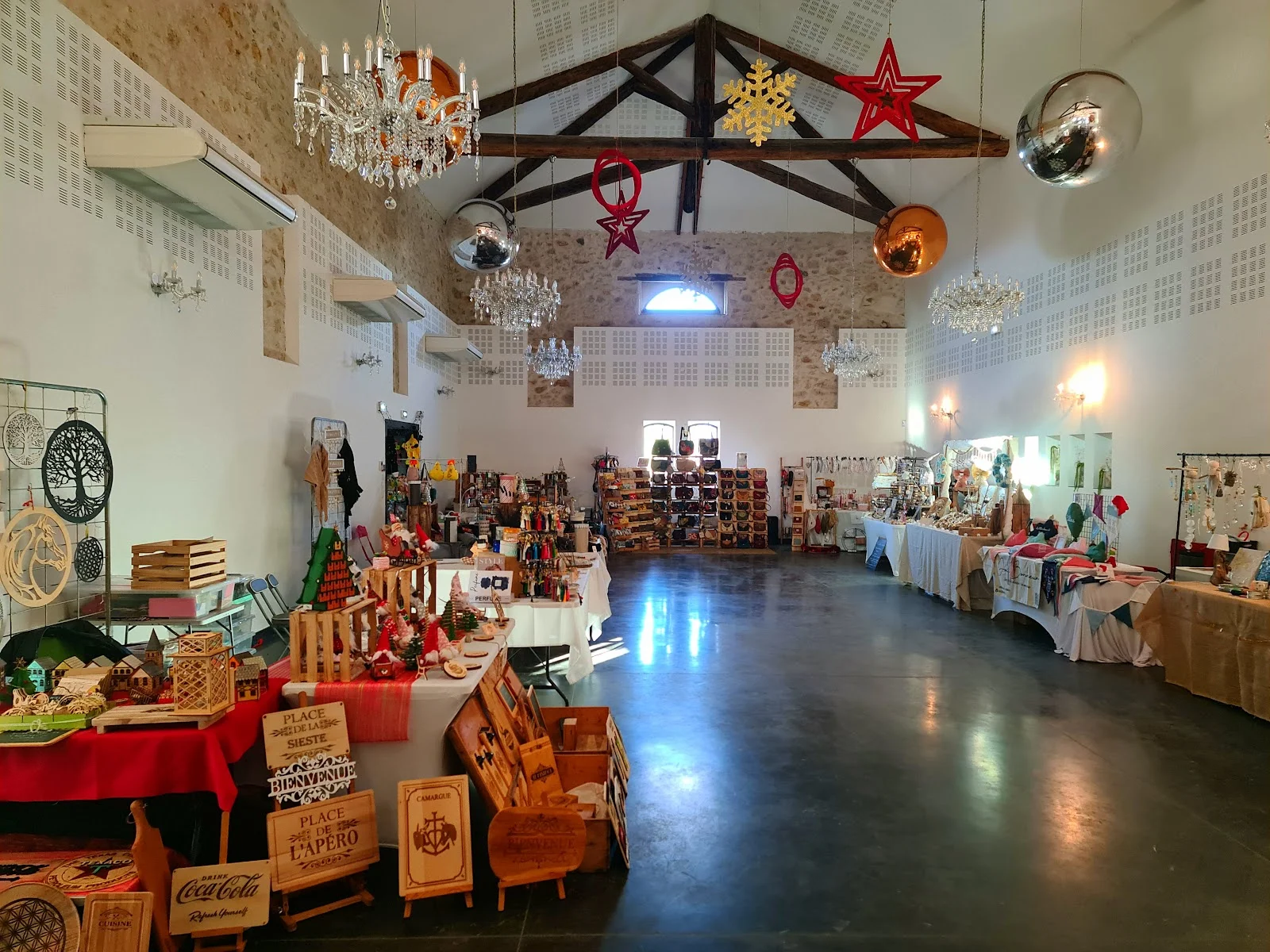 Marché de Noël intérieur dans la salle polyvalente du Domaine des Laux Hérault avec lustres cristal et décorations festives