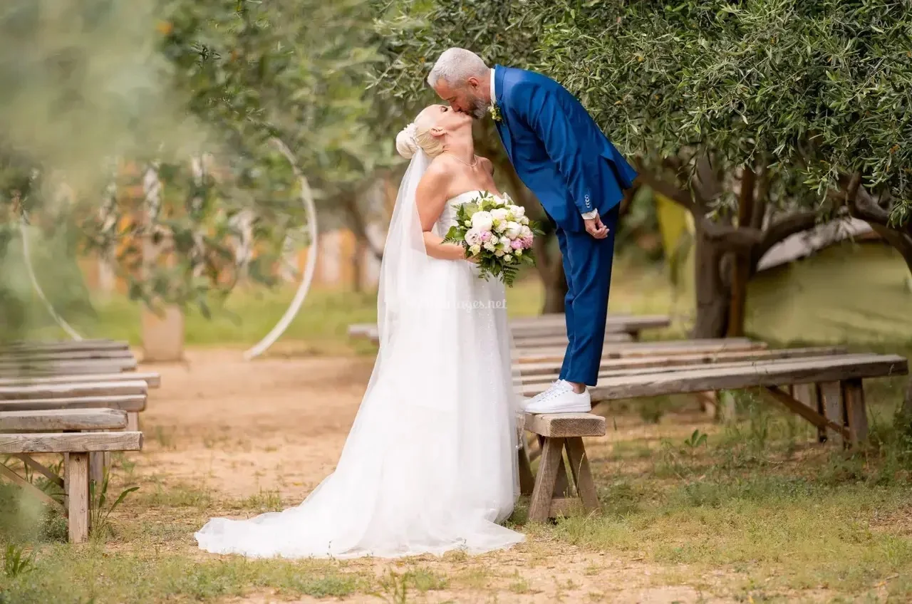 Couple de mariés s'embrassant dans l'oliveraie du Domaine des Laux Hérault lors de leur cérémonie de mariage