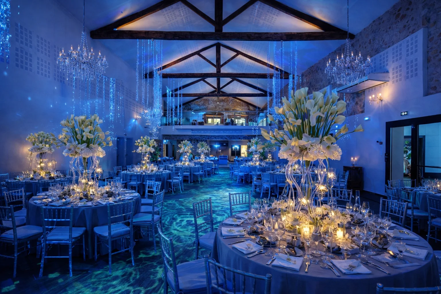 Salle de mariage du Domaine des Laux Hérault en ambiance aquatique bleue avec lustres cristal et compositions de callas blanches