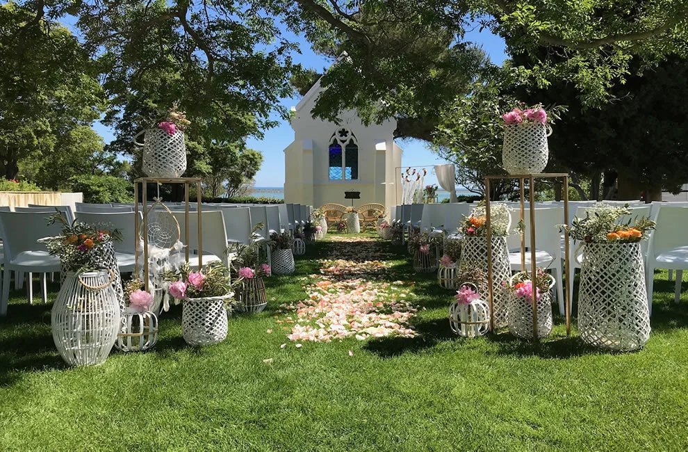 Cérémonie laïque bohème au Domaine des Moures avec lanternes blanches, pétales de roses et chapelle face à la mer, Hérault