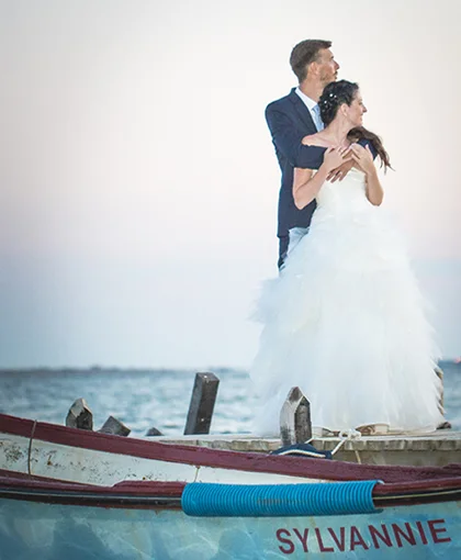 Couple de mariés en pose romantique sur une barque face à la mer au Domaine des Moures, Hérault