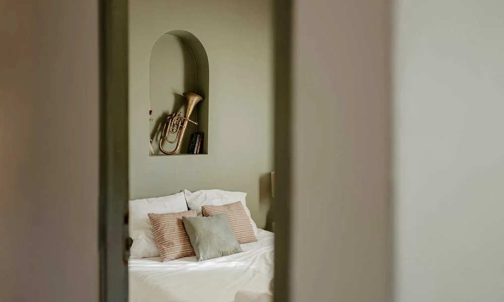 Chambre avec niche arquée et trompette dorée au Domaine des Rives Hérault mariage