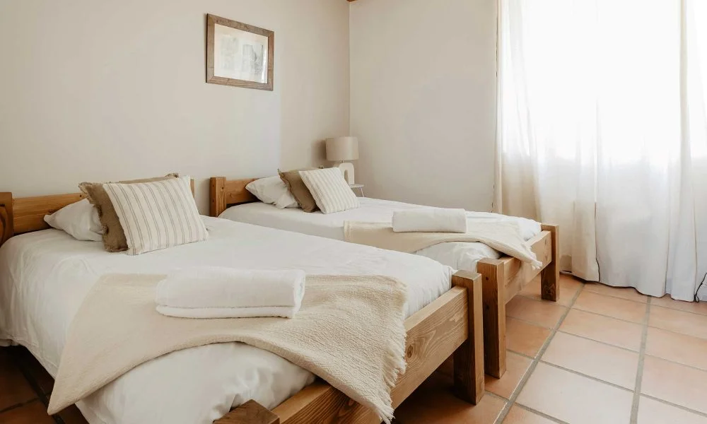 Chambre twin avec mur terracotta et fenêtre à carreaux au Domaine des Rives Hérault