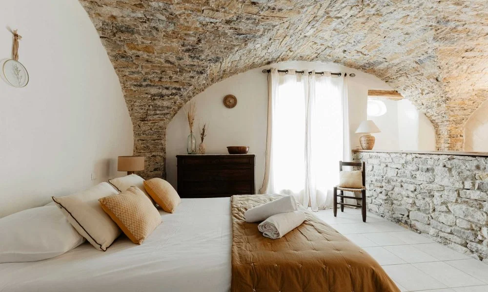 Suite avec voûte en pierre apparente et lit king size au Domaine des Rives, chambre de caractère mariage Hérault