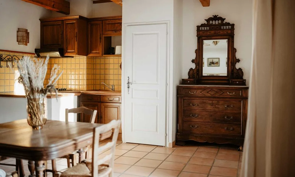 Cuisine avec commode ancienne sculptée et miroir au Domaine des Rives Hérault
