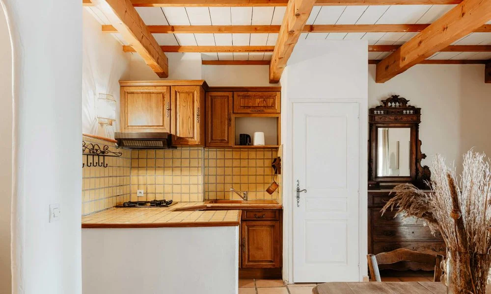 Cuisine provençale avec carrelage jaune et miroir sculpté au Domaine des Rives Hérault