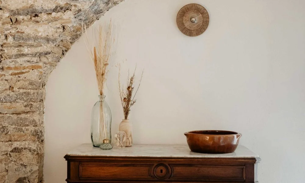 Détail décoration commode en marbre avec vases et herbes séchées au Domaine des Rives Hérault