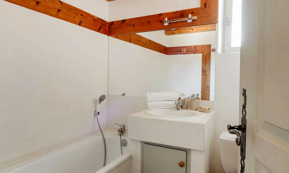 Salle de bain avec baignoire et poutres bois apparentes au Domaine des Rives Hérault