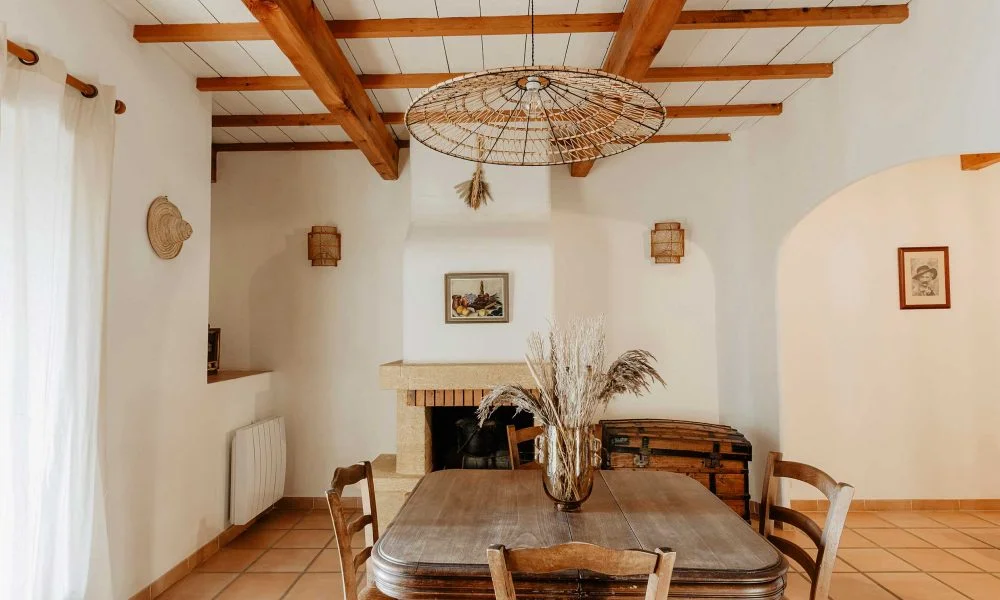 Salle à manger rustique avec cheminée et lustre en osier au Domaine des Rives Hérault mariage