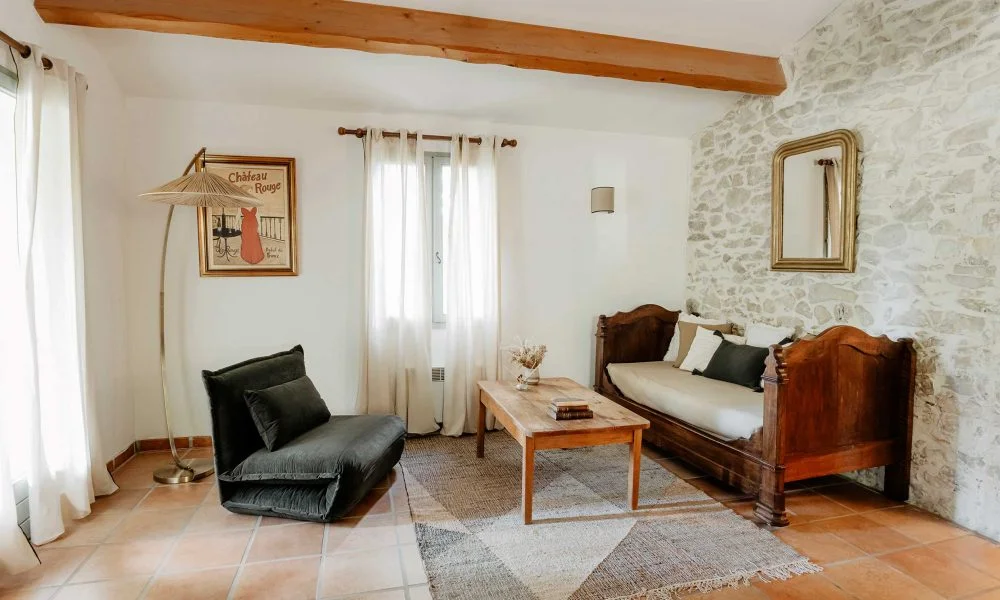 Salon du gîte avec mur en pierre et mobilier vintage au Domaine des Rives, hébergement mariage Hérault