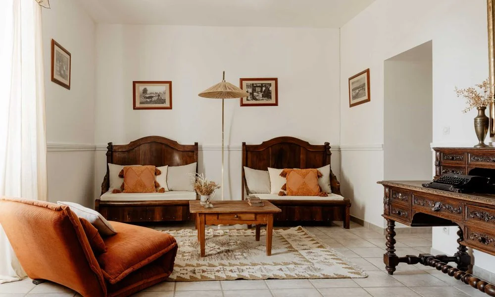 Salon avec mobilier ancien et fauteuil orange au Domaine des Rives, espace de réception mariage Hérault