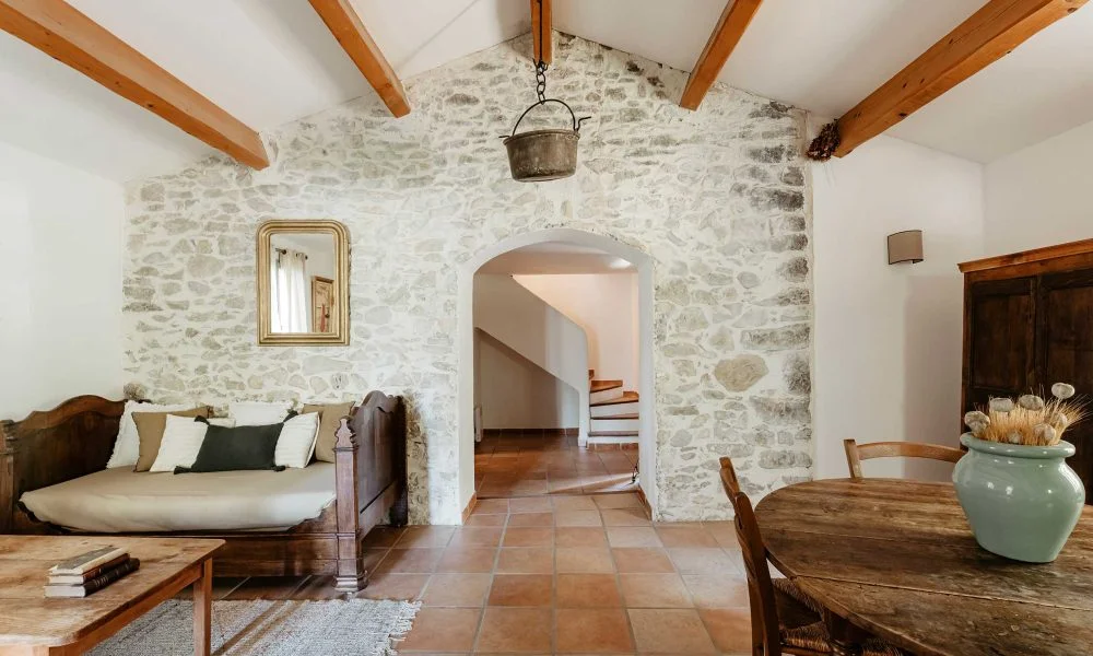 Salon avec mur en pierre apparente et arche au Domaine des Rives dans l'Hérault pour votre mariage