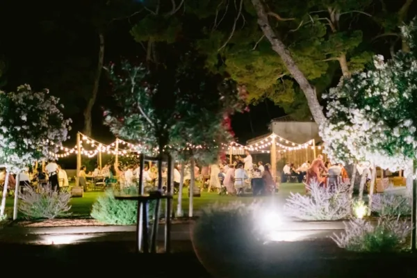 Jardin illuminé, convives attablés, ambiance festive nuit, Domaine du Mas Neuf Vic-la-Gardiole mariage Hérault Occitanie