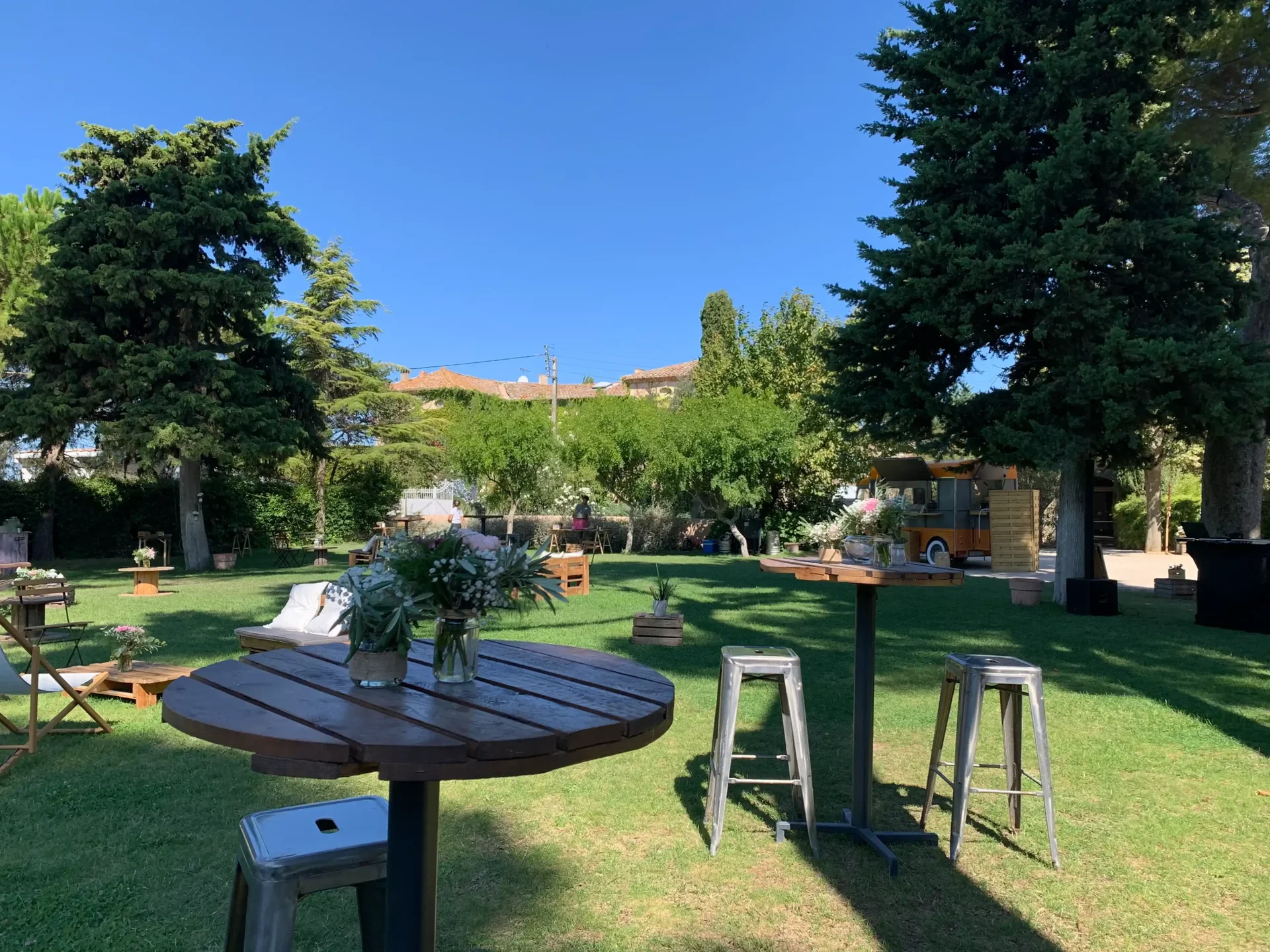 Jardin du Domaine Fon de Rey en Hérault aménagé pour un cocktail de mariage avec mobilier et food truck
