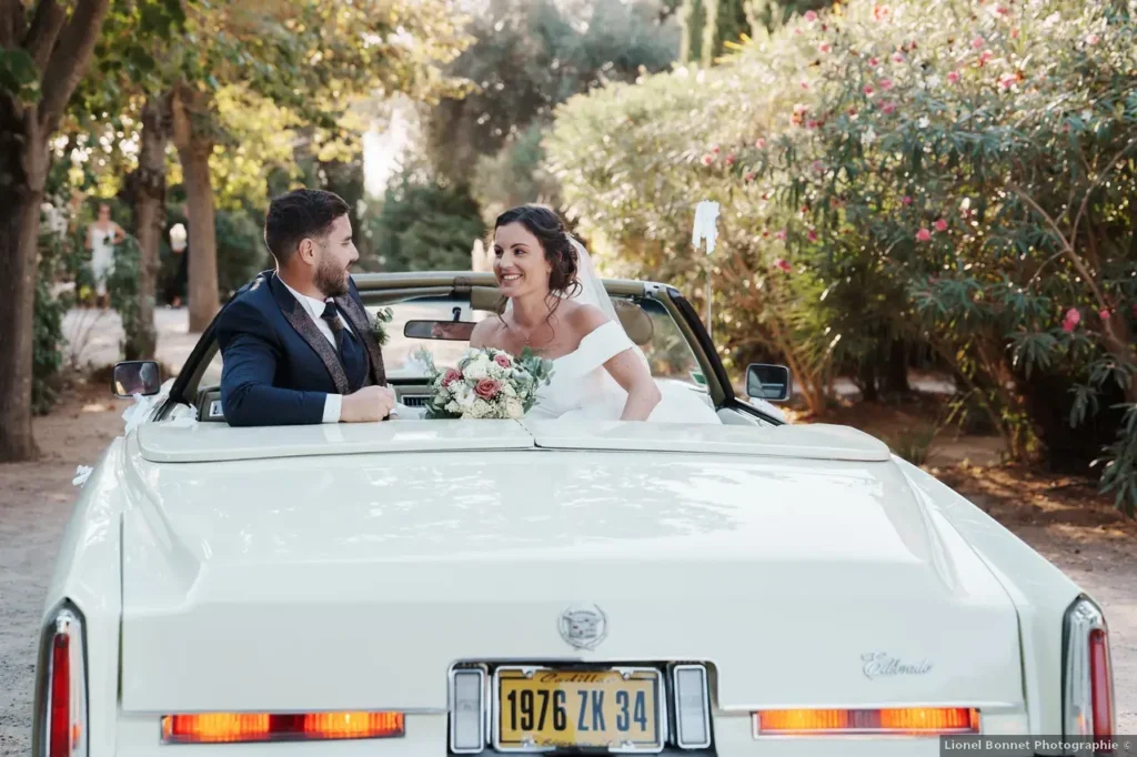 Couple de mariés dans une Cadillac vintage au Domaine Fon de Rey en Hérault - photo mariage