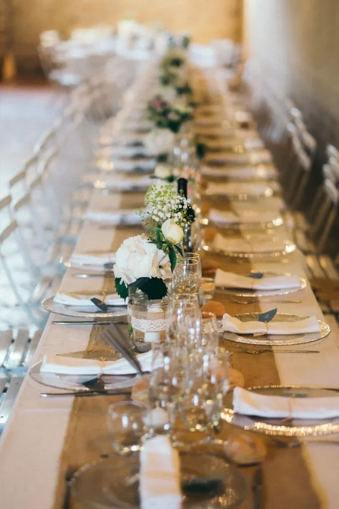 Table de mariage décorée au Domaine Fon de Rey en Hérault avec fleurs blanches et chemin de table doré