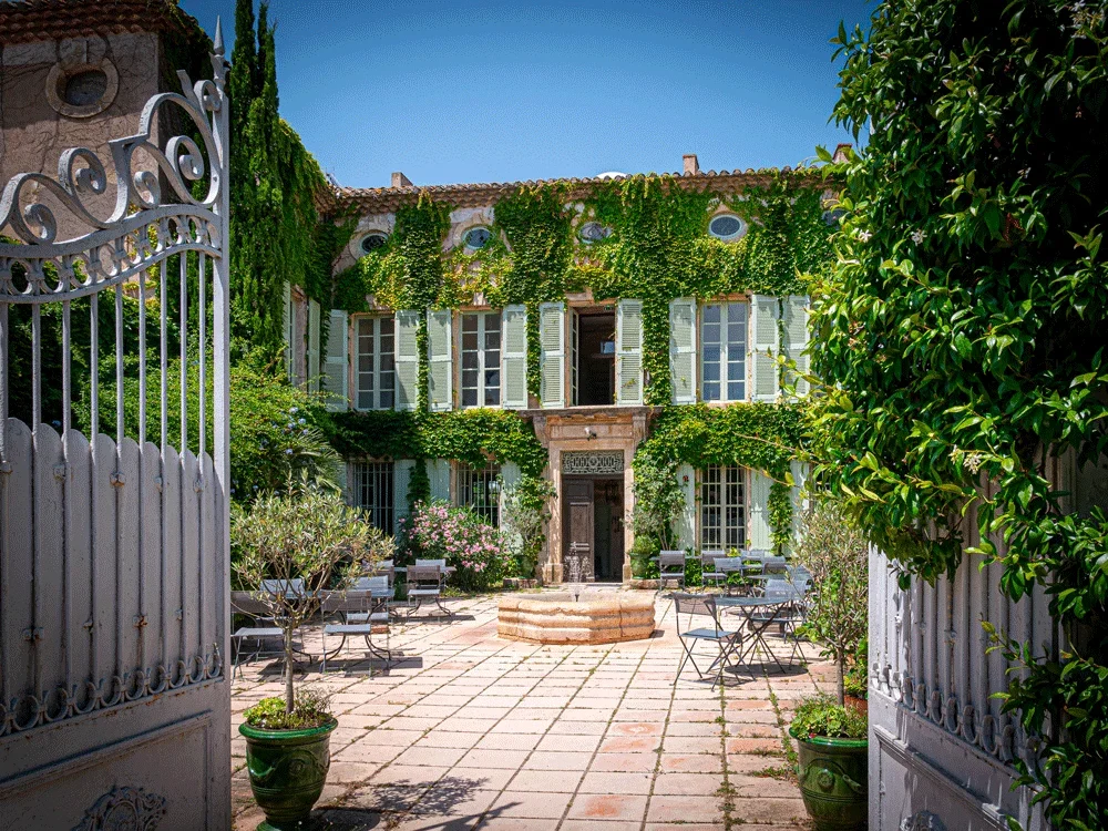 Domaine Fon de Rey Hérault - cour intérieure avec portail en fer forgé et façade en pierres couverte de lierre pour mariage