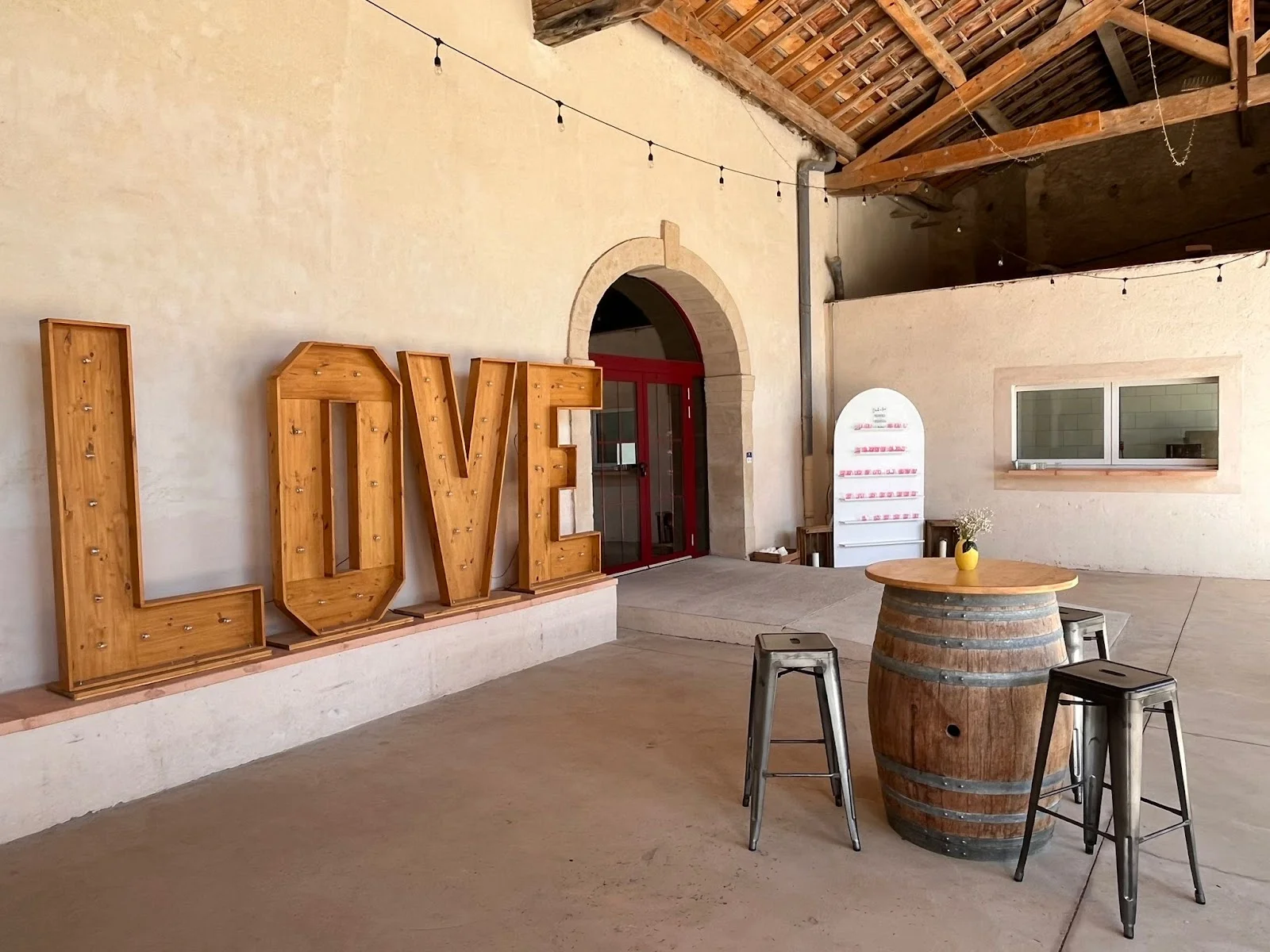 Salle de réception du Domaine Grande Canague décorée avec lettres LOVE et tonneaux pour un mariage en Hérault