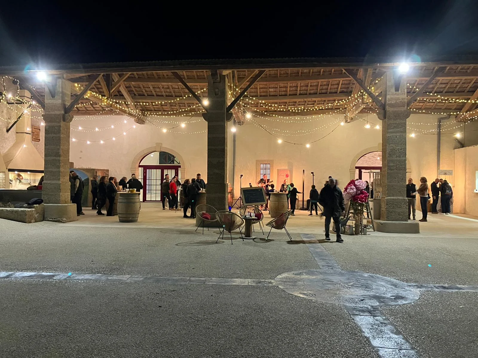 Soirée cocktail nocturne au Domaine Grande Canague en Hérault avec guirlandes lumineuses et invités sous le porche