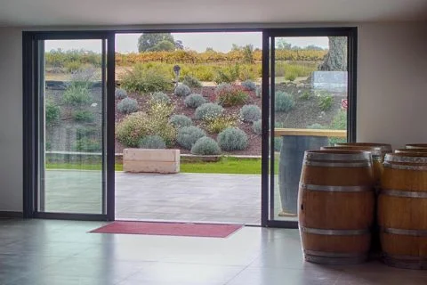 Intérieur chai domaine le Clos d'Elle barriques bois vue vignes mariage Hérault Occitanie