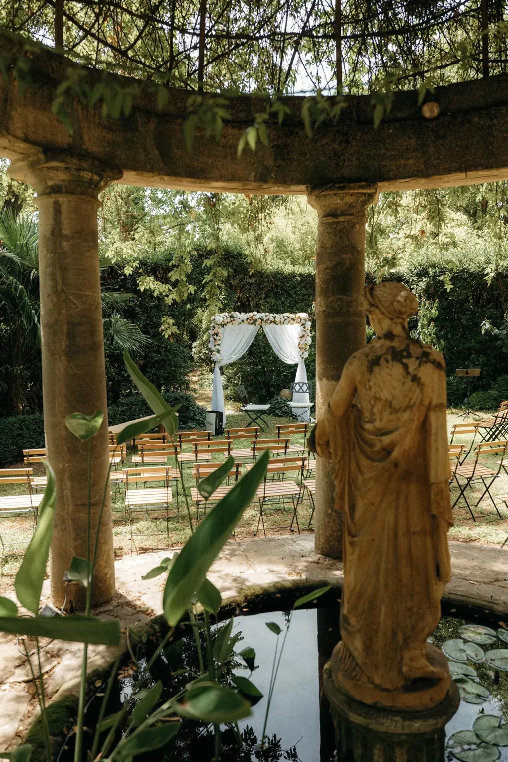 Kiosque à colonnes en pierre et statue classique encadrant la cérémonie de mariage au Domaine Le Petit Malherbes, Hérault